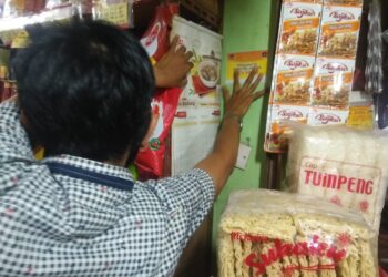 Petugas memasangkan stiker di toko bagi pedagang Pasar Raya yang sudah diswab.