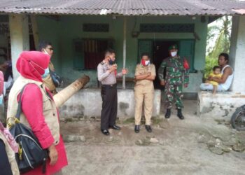 Petugas sedang memberikan arahan kepada warga agar membatalkan acara panjat pinang.