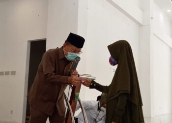 Ali Mukhni serahkan beasiswa kepada salah satu hafizah.