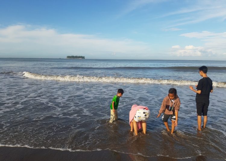 Anak anak bermain pasir di Pantai Gandoriah.