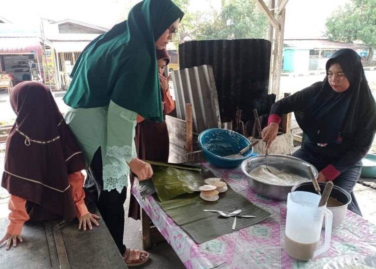 Ita (jilbab hitam), sedang melayani pembeli.