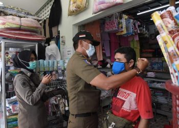 Elfis Chandra pasangkan masker kepada pedagang pasar.
