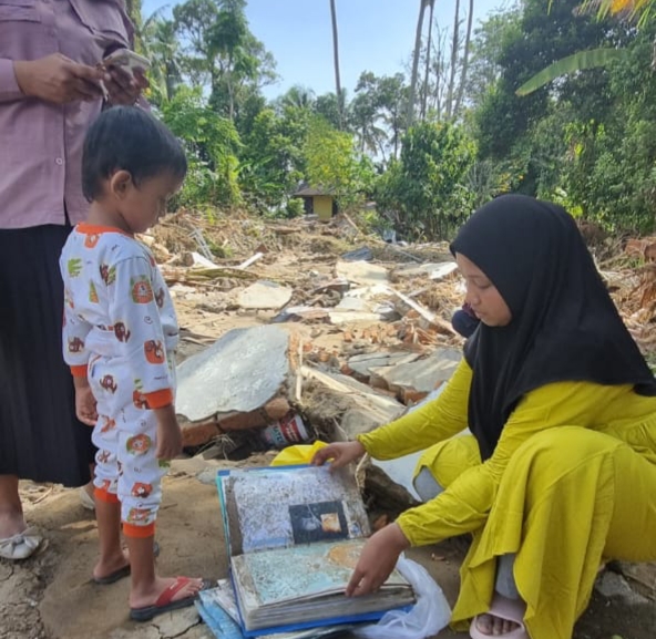 Dini sedang memeriksa dokumennya usai banjir.
